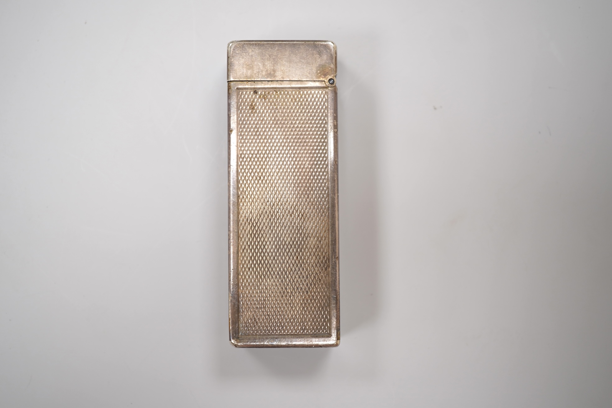 An early 20th century white metal oval locket, 40mm, on a silver chain, a silver plated Dunhill lighter, in Dunhill box, a white metal cased manual wind wrist watch and a tortoiseshell purse.